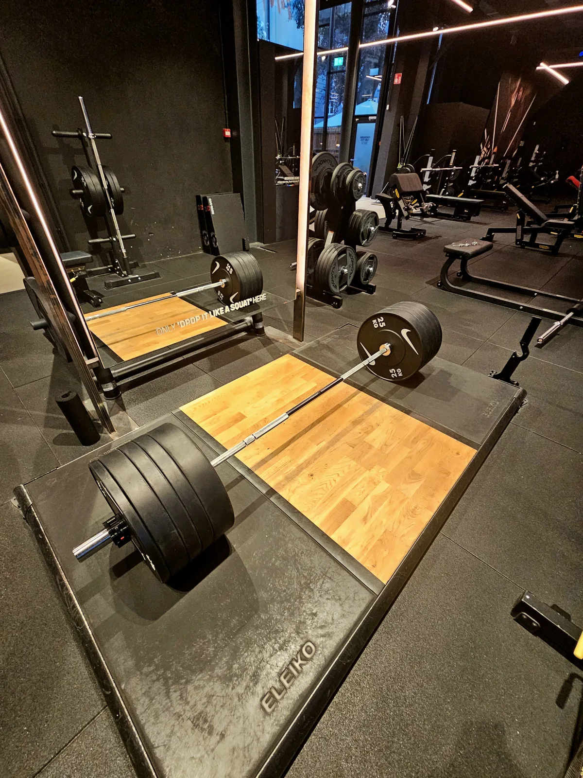 Een halter met zware schijven op een houten plateau in de sportschool, klaar voor een deadlift