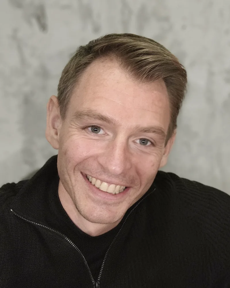 Cas, nu: portret met een lach, in een zwarte trui